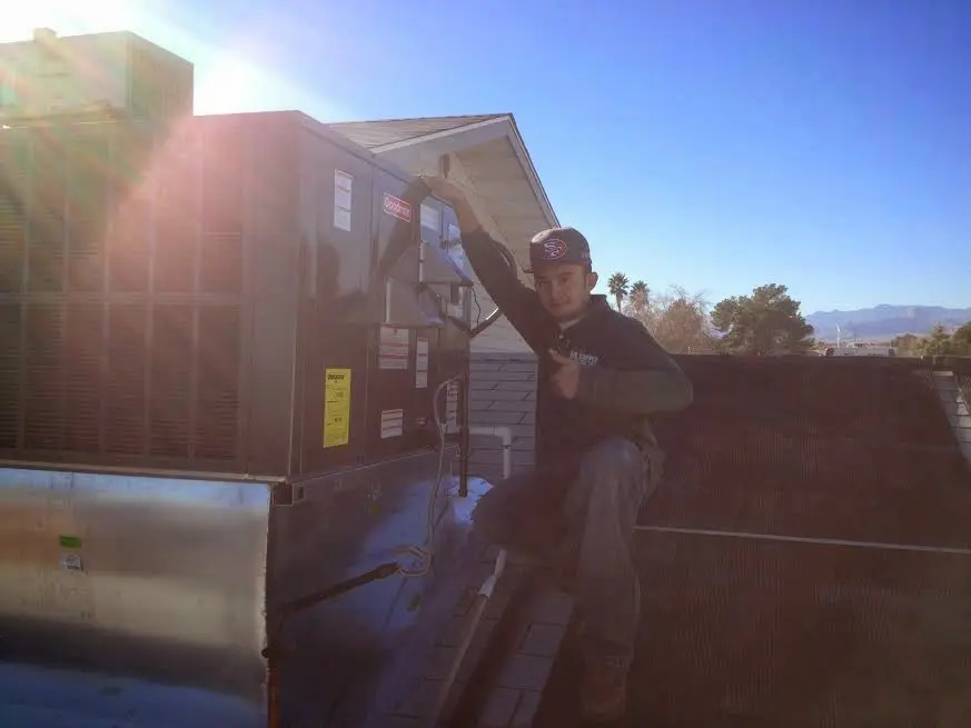 HVAC technician performing AC Tune-Up on a rooftop unit in Rathdrum